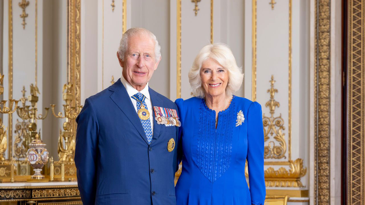 A man and woman in official clothing with military badges stand side by side. 