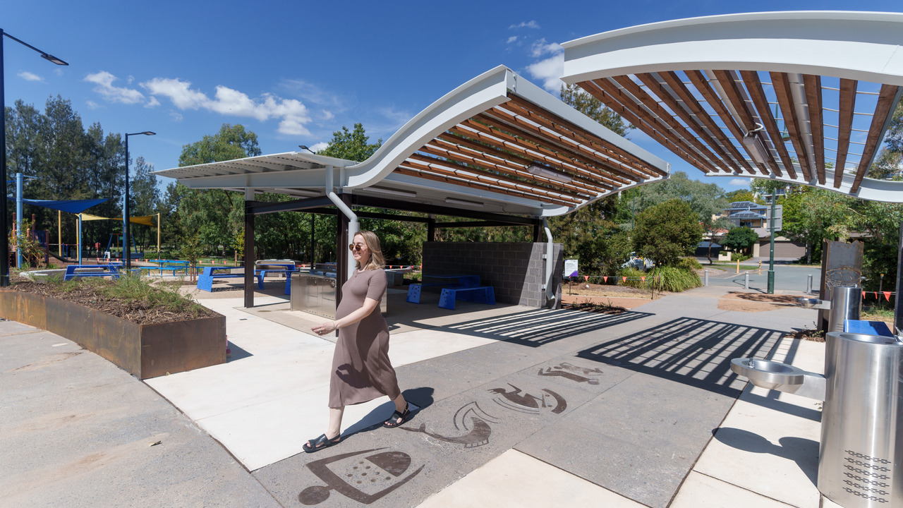 A woman walks through a park.